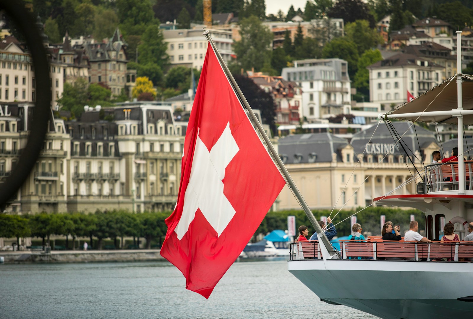 red and white sail boat on water near city buildings during daytime